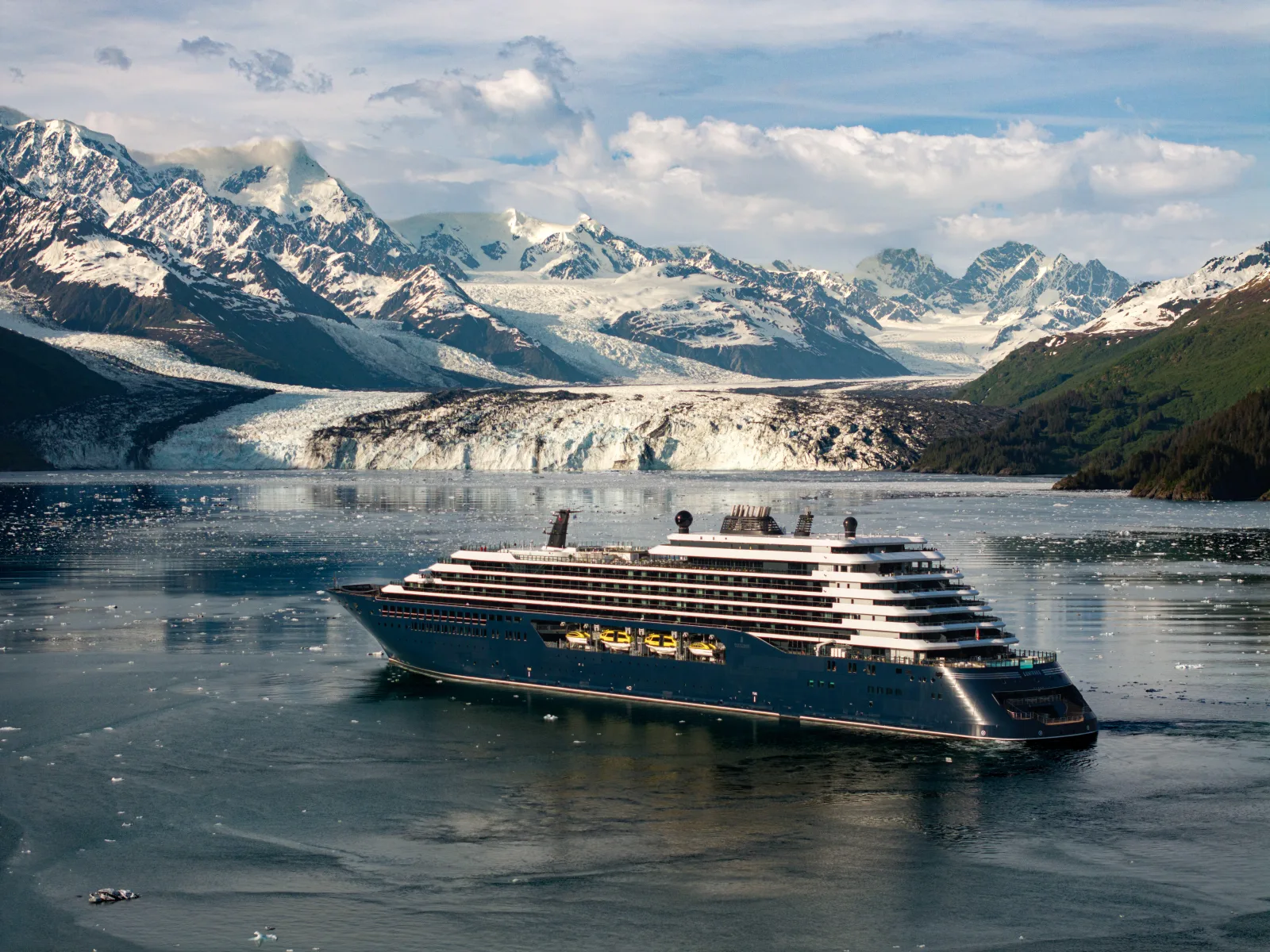 The Ritz-Carlton Yacht Collection yacht on the water in front of an Alaskan glacier