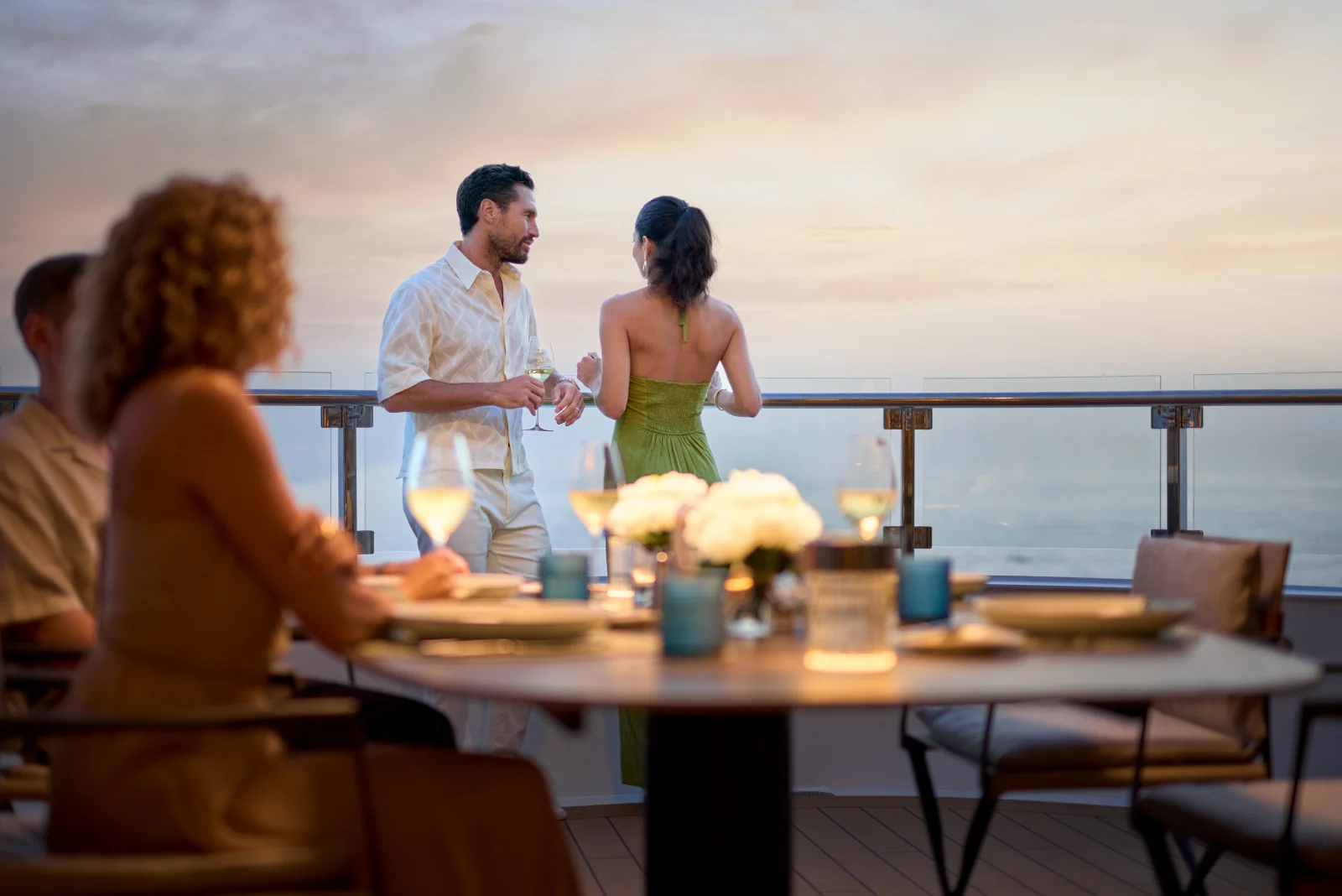 Guests enjoying drinks on the Owner's Suite terrace aboard Luminara at sunset