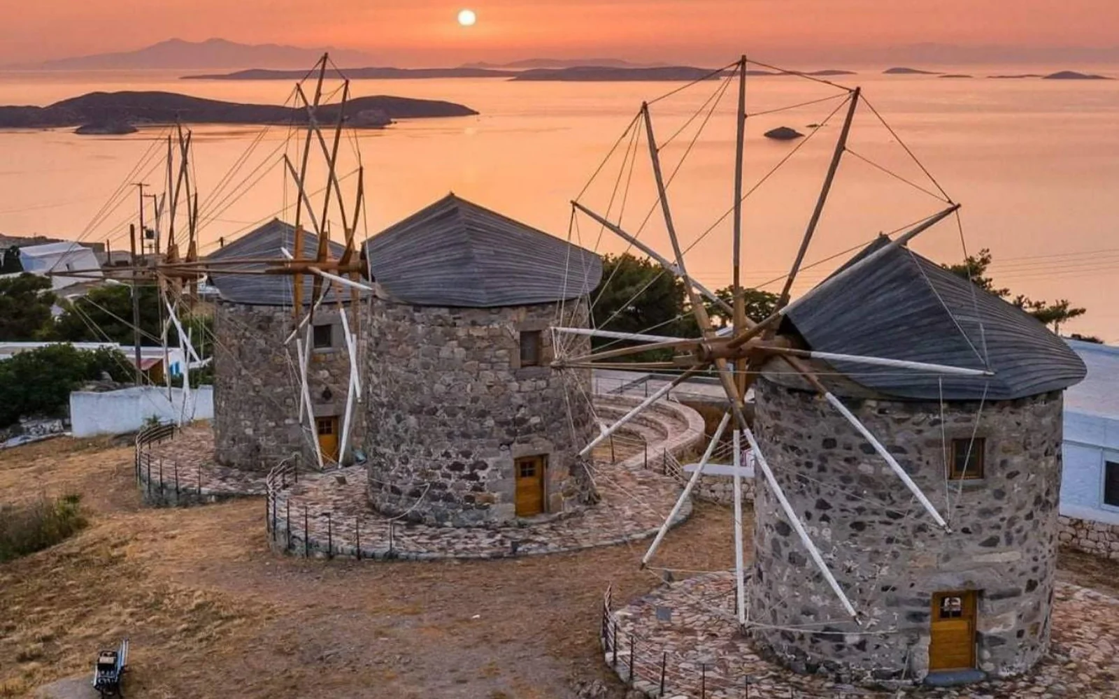 Traditional stone windmills overlooking the Mediterranean Sea at sunset