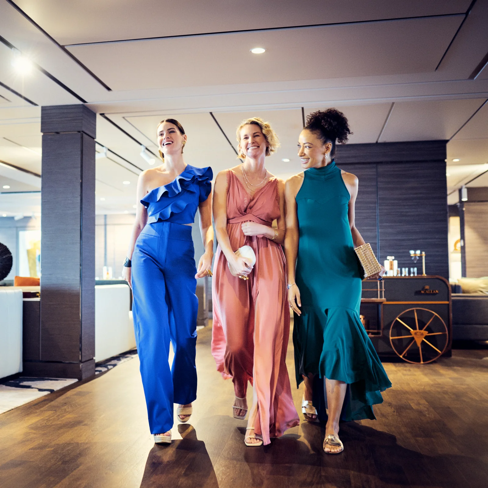 Three guests enjoying time together in a lounge aboard Evrima