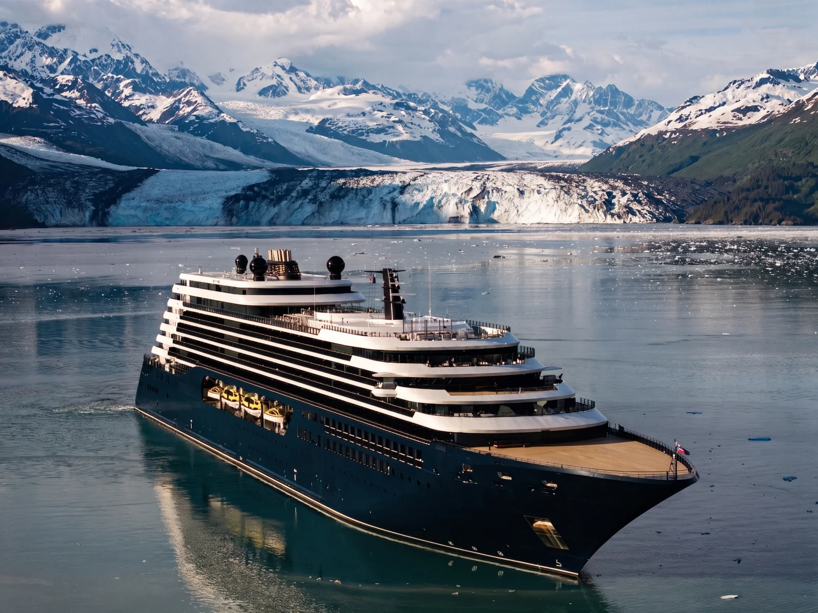 Luminara in Alaskan waters with a glacier and snow-covered mountains behind her